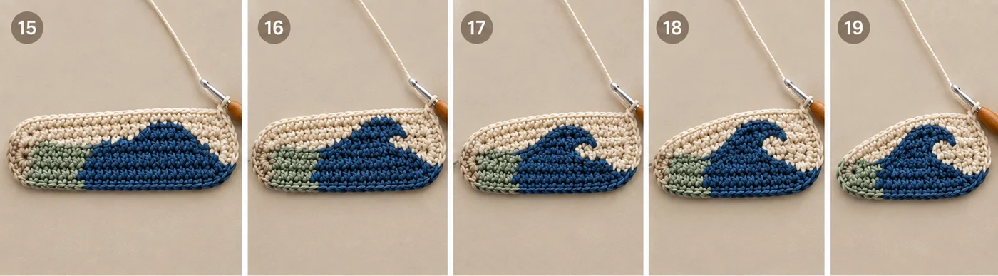 Step 3 of the ocean wave crochet coaster: Rows 15 to 19, with the navy crest curling over and a small cream eye appearing inside the curl above the sage water